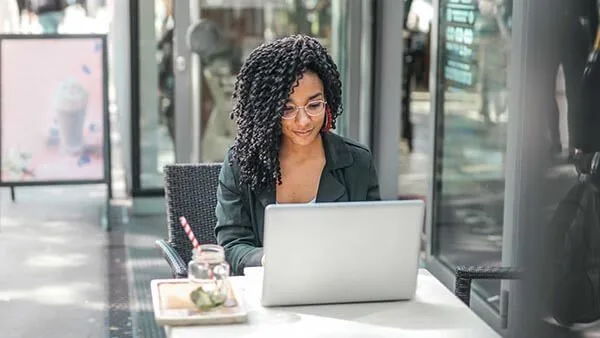 Black young woman writing on computer