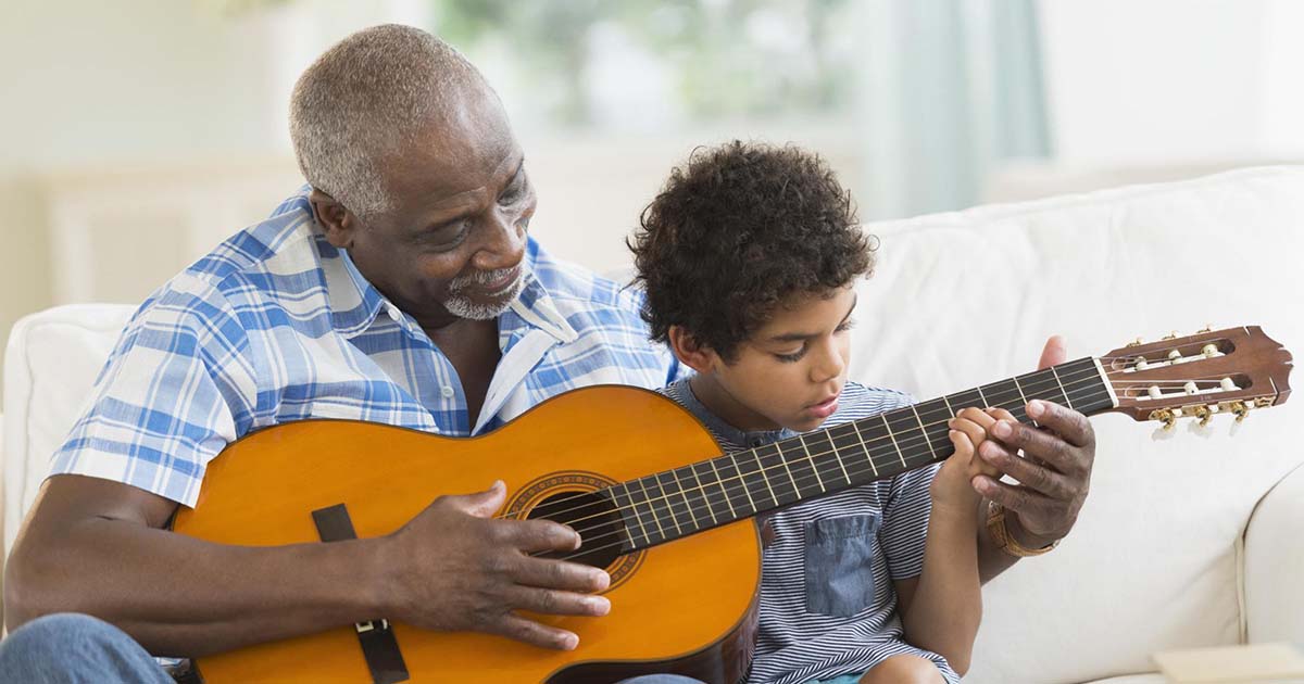 Father playing guitar with son